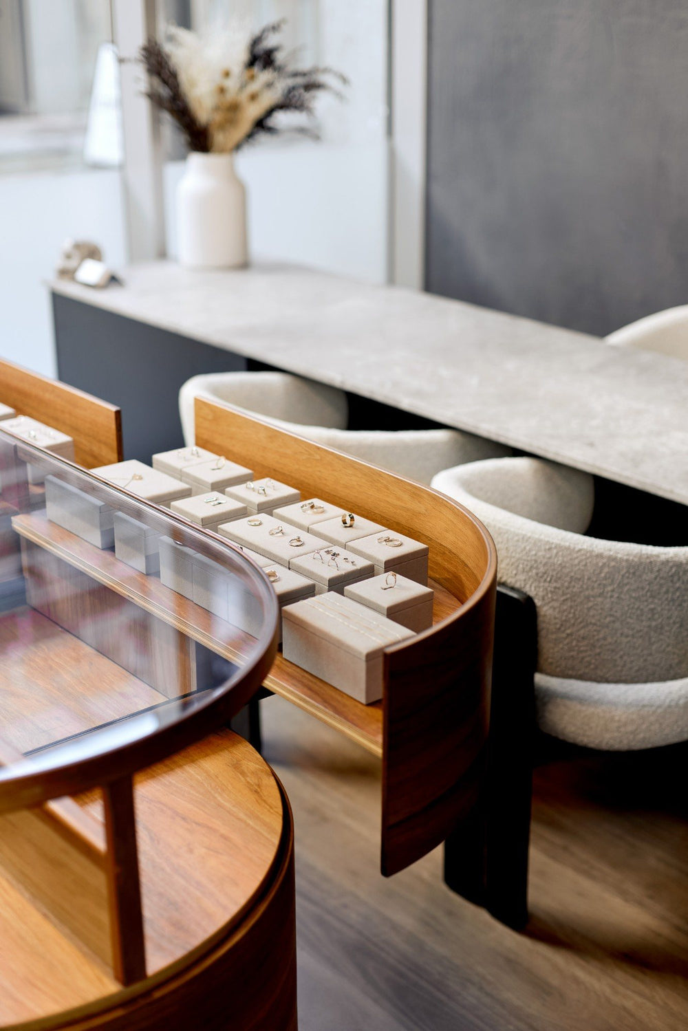 Rings in the curved timber and glass display case at the WILLIAM ÉDOUARD showroom