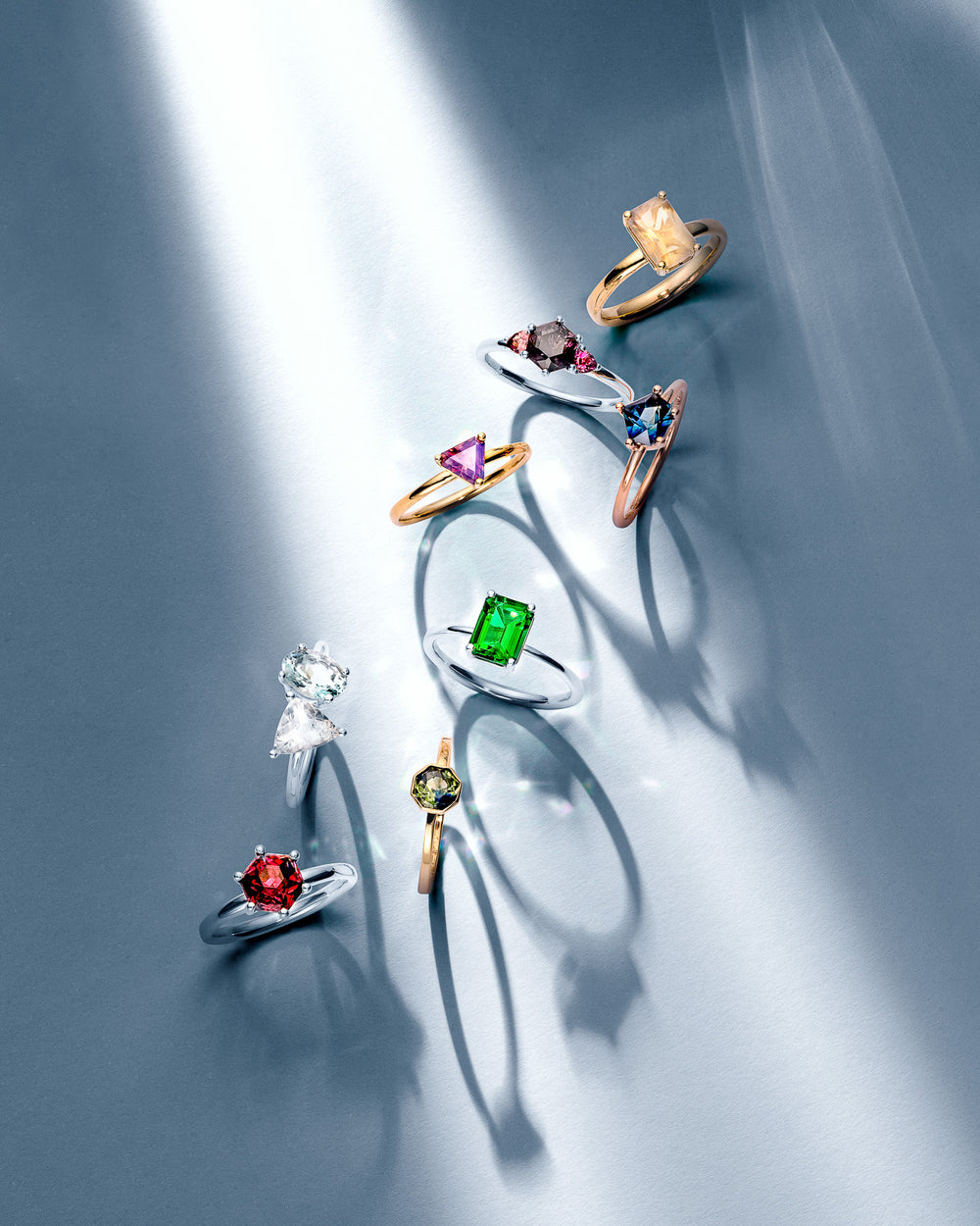 Assorted gemstone rings in gold and silver featuring emerald, sapphire, ruby and diamond designs by William Edouard