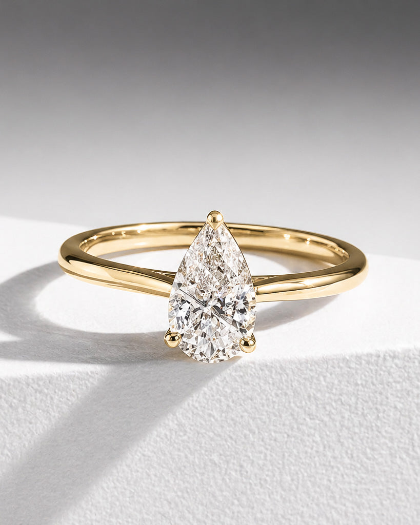Elegant pear cut diamond solitaire engagement ring in yellow gold by William Edouard
