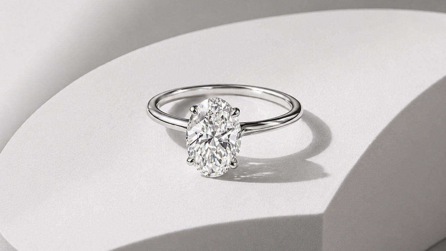 Oval diamond solitaire engagement ring in white gold with a classic four prong setting by William Edouard