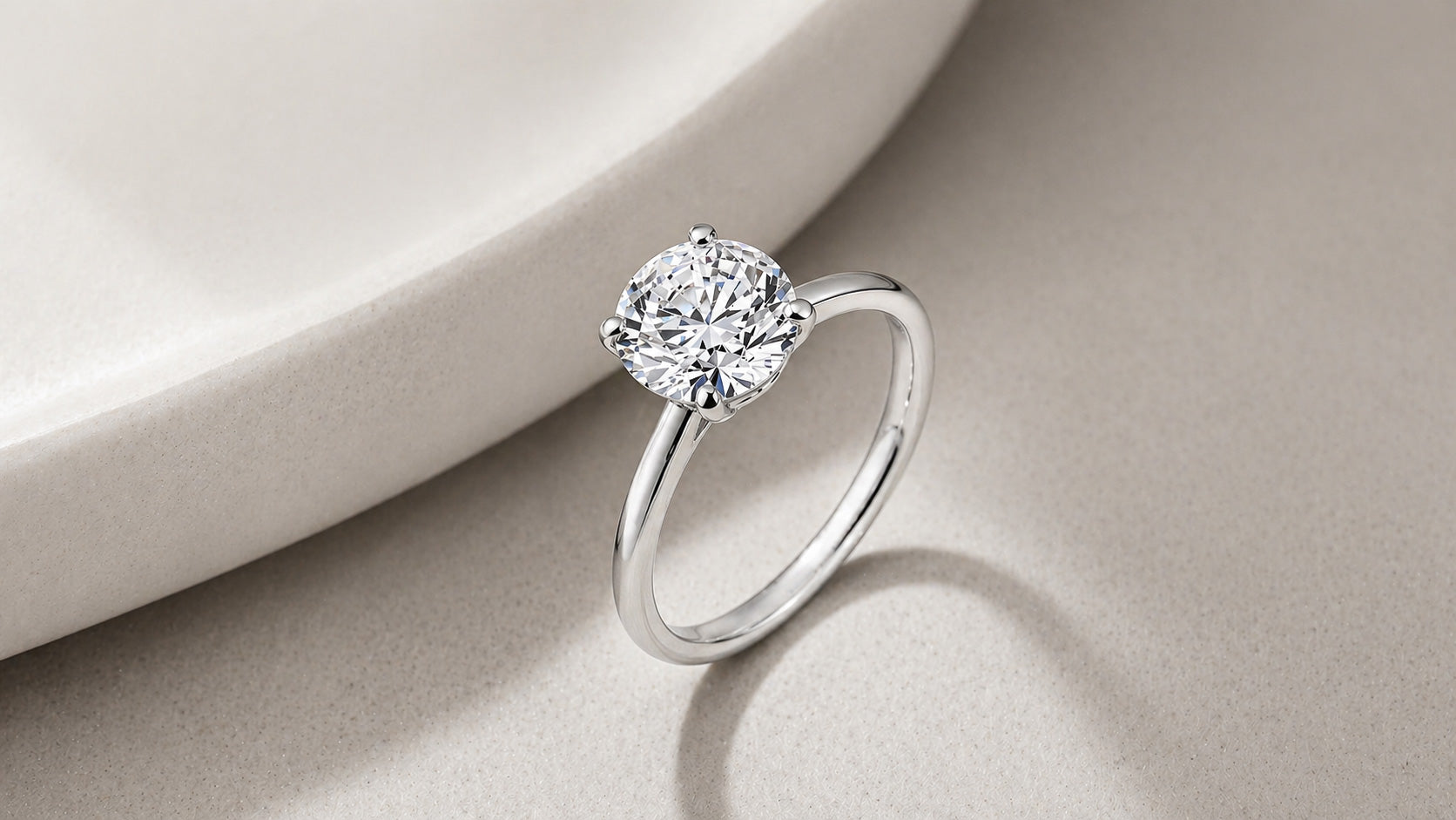Round diamond solitaire engagement ring in white gold with four prong setting by William Edouard